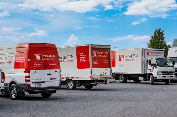 3 camions de service Portes RSM dans une cour commerciale